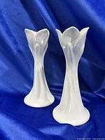 Two tulip-shaped candle holders standing upright