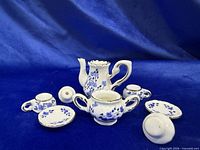 All components of miniature porcelain tea set disassembled