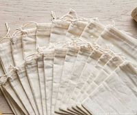 Fan display of multiple off-white cotton drawstring bags