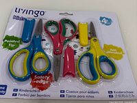 Front view of sealed retail package showing three colorful scissors and covers with feature text