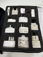 Adapters arranged in foam insert inside black leather zip case