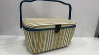 Full view of striped sewing basket showing handle and lid