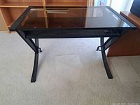 Front view of desk showing glass top and metal frame