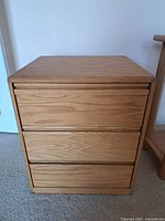 Front view of three-drawer bedside dresser, drawers closed