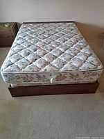 Full view of platform bed with mattress and nightstand partially visible