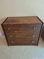 Front view of three-drawer bedside cabinet