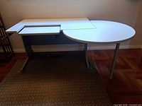 Full view of white modular desk showing main surface, keyboard panel and circular extension