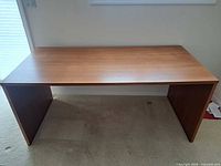 Top view of rectangular wooden desk showing flat surface and side panels