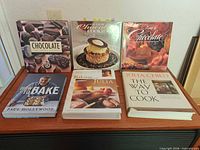 Front view of all six cookbooks arranged on table