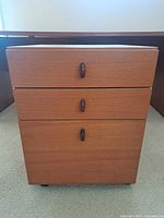 Front view showing three drawers and pulls