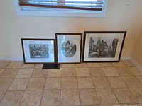 Three framed prints side by side on floor