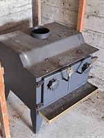 Front and side view of steel wood stove showing dual doors, handles, legs, brass trim