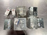 Group shot showing all nine items: seven galvanized steel boxes and two white receptacles