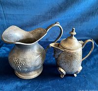 Front view of pewter creamer and silver-plated copper syrup pot