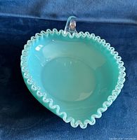Top view of turquoise blue opalescent dish showing ruffled clear rim and applied handle