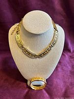 Necklace on bust and bangle in front showing overall design