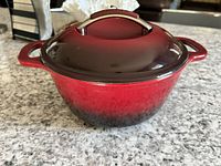 Dutch oven with lid on showing burgundy-to-black ombre exterior and side handles