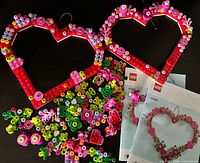 Two assembled red heart frames, loose floral pieces, two manuals visible