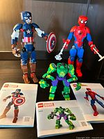 Front view of all three assembled LEGO figures with manuals laid out