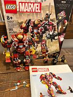 Front view of set with Hulkbuster, minifigures, instruction manual and box front