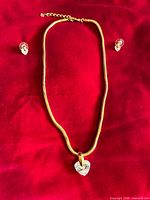 Full view of necklace and earrings on red background