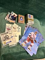Top-down view of full lot showing sealed Gretzky deck, sealed PGA deck, Griffey Jr. card set, Elmira Poultry oversized cards, vintage patches, Bill Durnan card