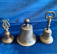 Front view of all three brass bells showing design and patina
