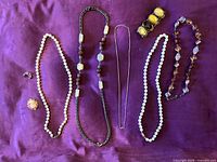 All jewelry pieces laid out on purple background