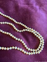 Close view of pearls showing creamy colour, lustre, and knotting