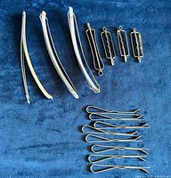 All 15 metal hair accessories displayed on blue fabric
