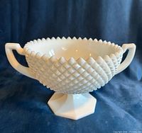 Front view of milk glass pedestal bowl showing handles, diamond hobnail surface and sawtooth rim