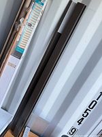 Two brown extruded rails leaning against wall