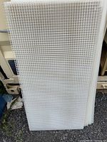 Two stacked white plastic eggcrate panels leaning upright