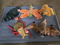 Group shot of all five plush toys on a blue surface