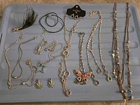 Full view of all costume jewelry pieces laid out on blue surface
