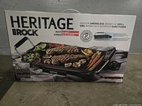 Front of sealed retail box showing Heritage The Rock Indoor Smokeless Barbecue Grill