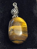 Front view of stone pendant displaying striped coloration and metal cap