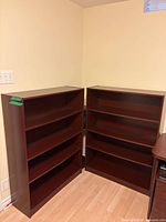 Both cherry veneer bookcases side-by-side