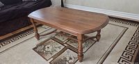 Three-quarter view of oak-veneer coffee table on rug