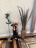 Group view showing statue, woven vase with reeds, glass vase, onyx pears, artificial flower