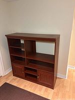 Front view of entertainment center showing shelves, cabinets, molding