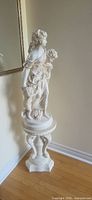 Statue on pedestal in corner view full height