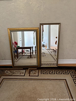 Both mirrors standing against wall showing sizes and gold frames