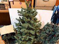 Full view of artificial tree with garlands and box