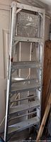 Ladder folded against wall showing full height and seven steps