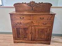 Front view showing drawers, cabinet doors, and carved backsplash