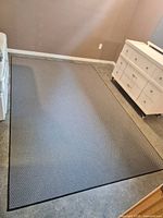 Full view of rectangular gray/black geometric rug in room