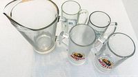 Group shot of pitcher and four beer mugs showing sizes and styles