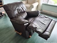 Front view of dark brown leather recliner with footrest extended
