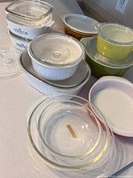 Group of vintage Corning Ware and Pyrex casseroles and bowls with lids